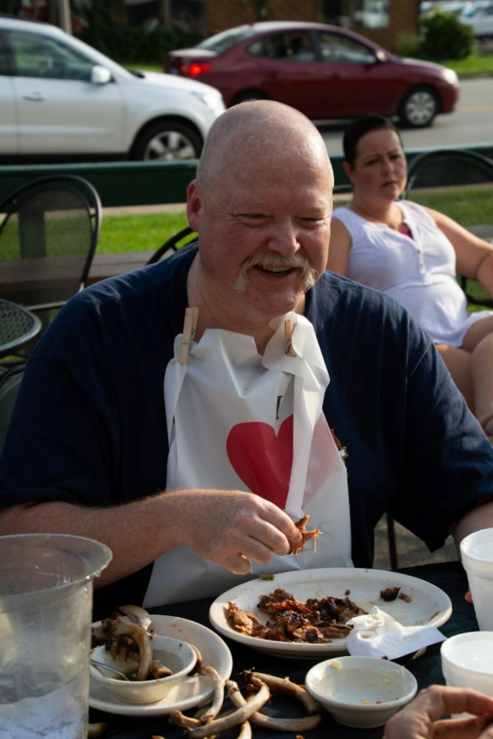 A member of the Muncie Fire Department laughs in between bites at the fifth annual Battle of the Badges rib-eating challenge Sept. 18, 2018, at Texas Roadhouse in Muncie. The police department and fire department competed to raise money for selected charities. Leslie Gartrell,DN