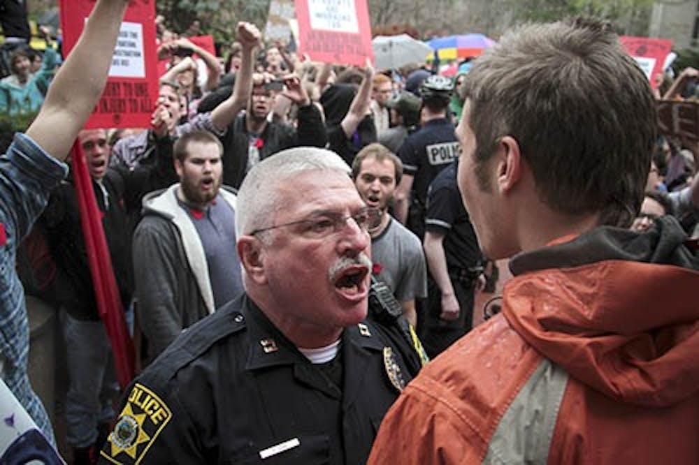 Capt.Thomas Lee of the Indiana University Police Department yells at a protestor to clear the sidewalk on April 10, 2013 outside of the Trustee Meeting. University students are protesting tuition hikes and diversity of the campus. PHOTO PROVIDED BY CLAYTON MOORE AND THE INDIANA DAILY STUDENT