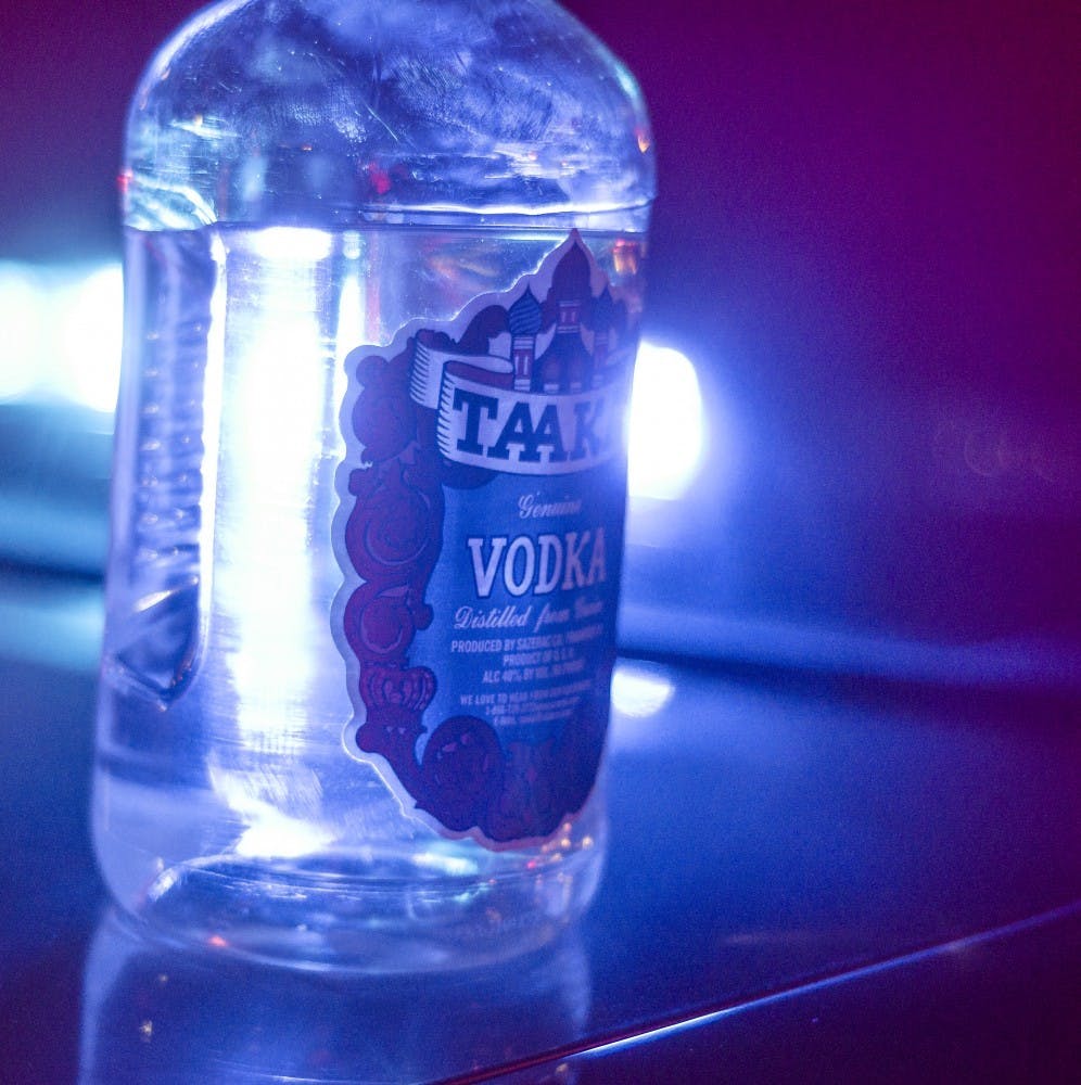 A confiscated bottle of Vodka sits on the hood of Indiana State Excise officer Brandon Thomas's car early on Nov. 3. The underage student who was carrying the vodka on him was written a ticket for minor possession, a charge usually handled by the Delaware County deferral program. DN PHOTO COREY OHLENKAMP