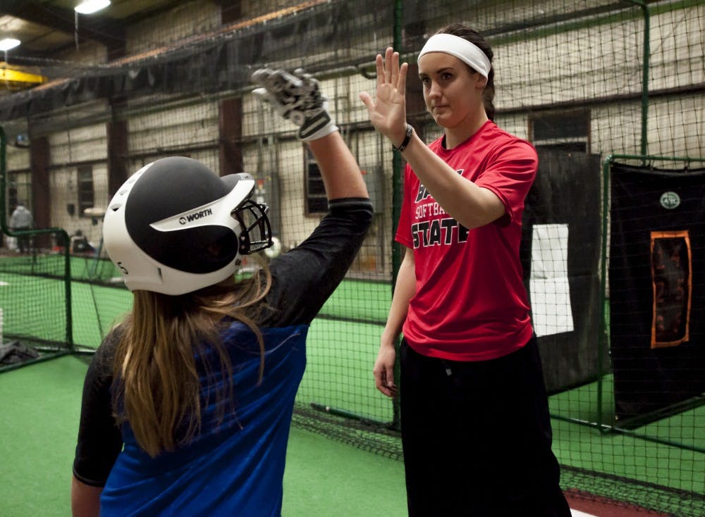 Jenny Gilbert high fives McKenzie Stark, 9, after a successful batting practice at the 5 Tools Academy where Gilbert volunteers her time. Stark watched Gilbert play all four years of college, and was very excited to start working with her. 