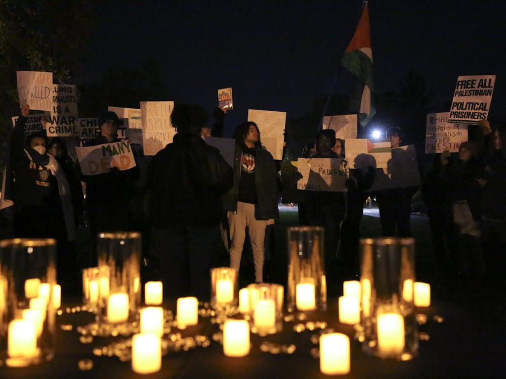 Peaceful protestors listen as their member gives a speech calling for the freedom of Palestine at a peace vigil Nov. 1 at Beneficence Statue. Andrew Berger, DN