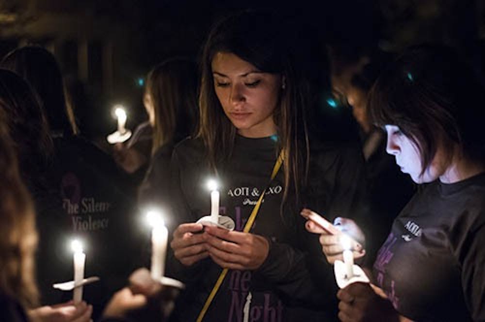 Students light candles outside the David Owsley Museum of Art and the start of the Take Back the Night march. DN PHOTO JONATHAN MIKSANEK