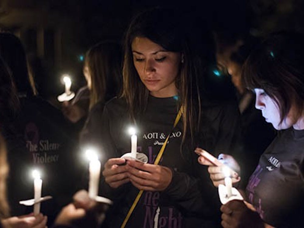 Students light candles outside the David Owsley Museum of Art and the start of the Take Back the Night march. DN PHOTO JONATHAN MIKSANEK
