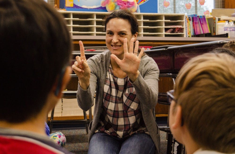 <p>Ball State professor Beatriz Cobeta holds up six fingers to the third graders in Mrs. Karne's class, Sept. 25, at the Burris Laboratory School. Cobeta volunteers at the school to teach Spanish for a brief time in class. Students or professors volunteer their time to teach Spanish basics, such as numbers and letters. <strong>Stephanie Amador, DN</strong></p>