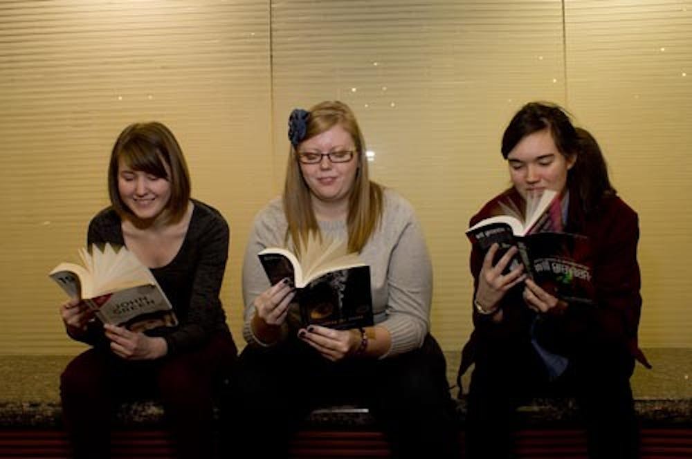 From left, Hannah Lindgren, MacKenzie Cox and Sarah Fischer pose with books written by John Green on Jan. 15, 2013. All three students consider themselves part of the Nerdfighter community, a concept created by fans of the author and his brother.  DN PHOTO TAYLOR IRBY