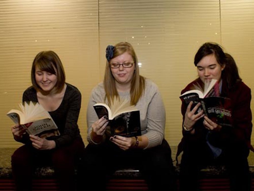 From left, Hannah Lindgren, MacKenzie Cox and Sarah Fischer pose with books written by John Green on Jan. 15, 2013. All three students consider themselves part of the Nerdfighter community, a concept created by fans of the author and his brother.  DN PHOTO TAYLOR IRBY