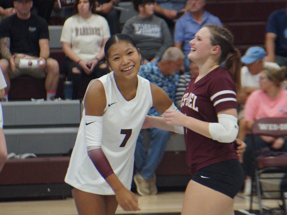Freshman Joy Toney, 7, and Senior KyLynn New, 1, hug after another point scored. Their next game will be at the Eastbrook Invitational Sept. 20 at 9 a.m. PHOTO BY NICK ROARK