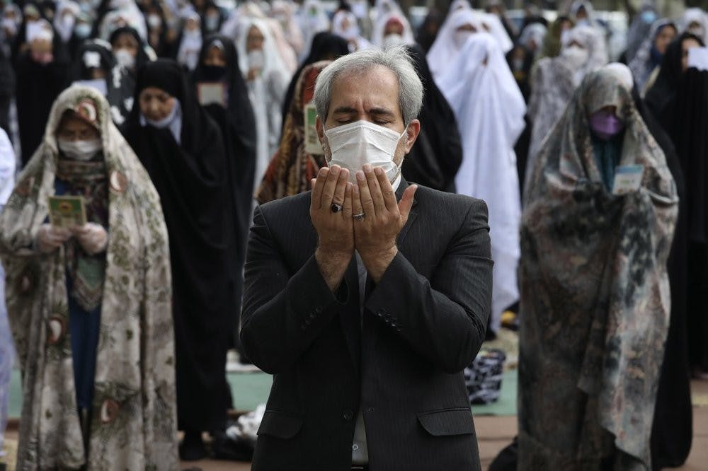 Worshippers wearing protective face masks offer Eid al-Fitr prayers outside a mosque May 24, 2020, in Tehran, Iran. Muslims worldwide celebrate one of their biggest holidays under the long shadow of the coronavirus. (AP Photo/Vahid Salemi)