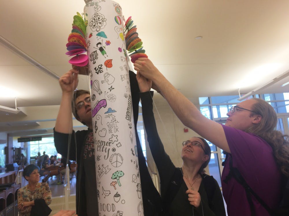 Students sign an&nbsp;8-foot peace pole in the Atrium today.&nbsp;The purpose of the pole is to honor those who have died over the years in April as a result of tragedies and to promote nonviolence on campus and in the community.&nbsp;Kara Berg // DN&nbsp;