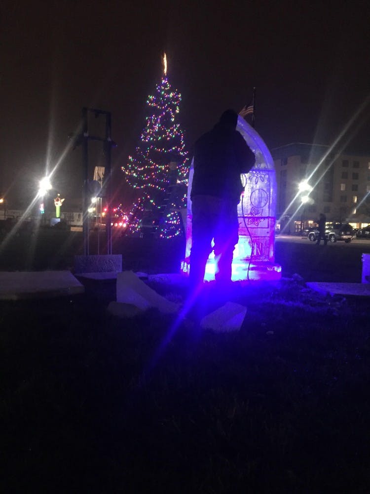 Indiana Ice Studio founder Stephen Koch had a crowd of about 40 people gathered around two watch him sculpt. Koch transformed a rectangular block of ice to a holiday moment with the&nbsp;"DWNTWN" logo at the base.&nbsp;DN PHOTO CASEY SMITH