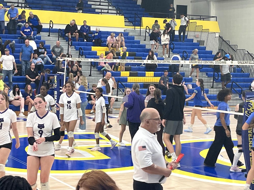 Muncie Central girls volleyball coach Kate Hughes delivers handshakes to the winning Lady Cougars. The Lady Bearcats lost all three sets in the match. Photo by Evan Shotts.
