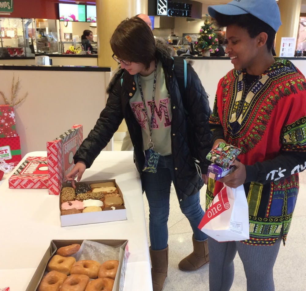 <p>Students take free donuts being handed out by Square Donuts in the Atrium Monday, Nov. 27. Students can now buy Square Donuts in each of the residence halls’ dining areas, the Atrium and the Student Center. Ball State University Dining, Photo Provided</p>