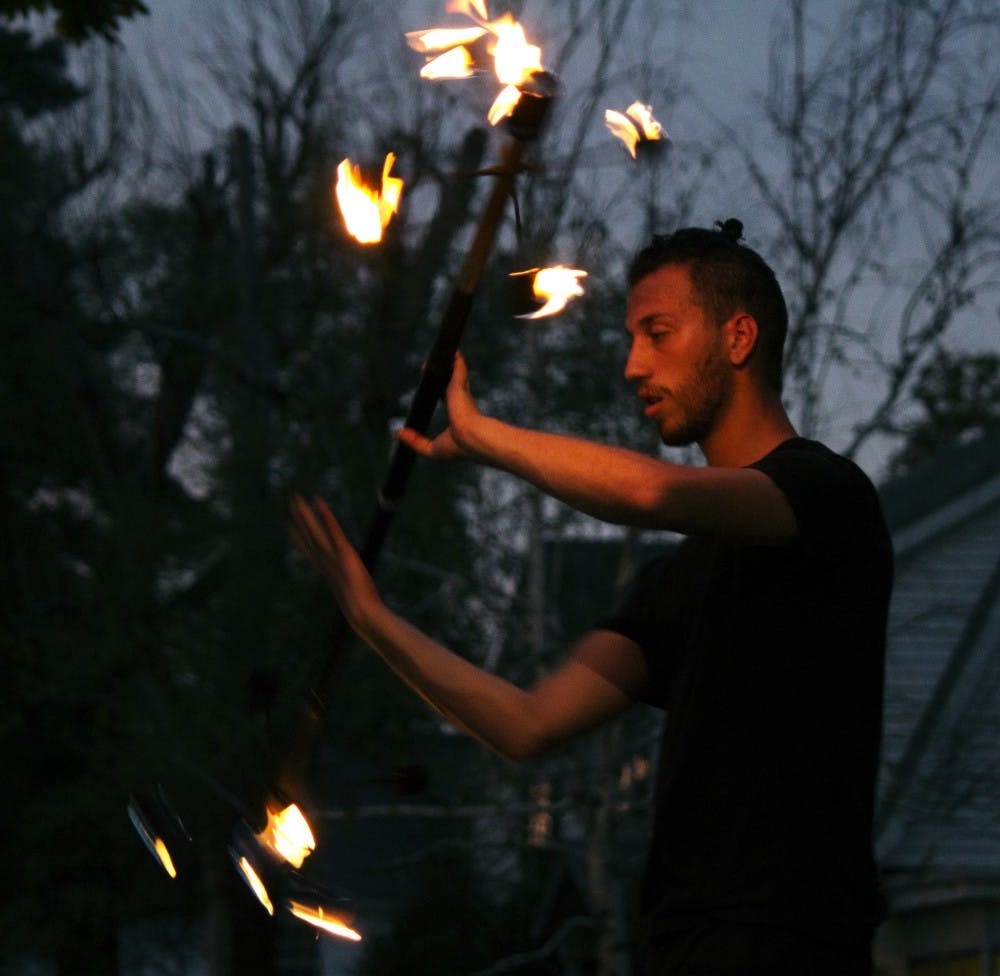 Cincinnati Circus Company’s fire performer, Adam Leite, twirls a lit pole on Monday, Sept. 28 at 7:42 p.m. at the Homecoming Village festival. 