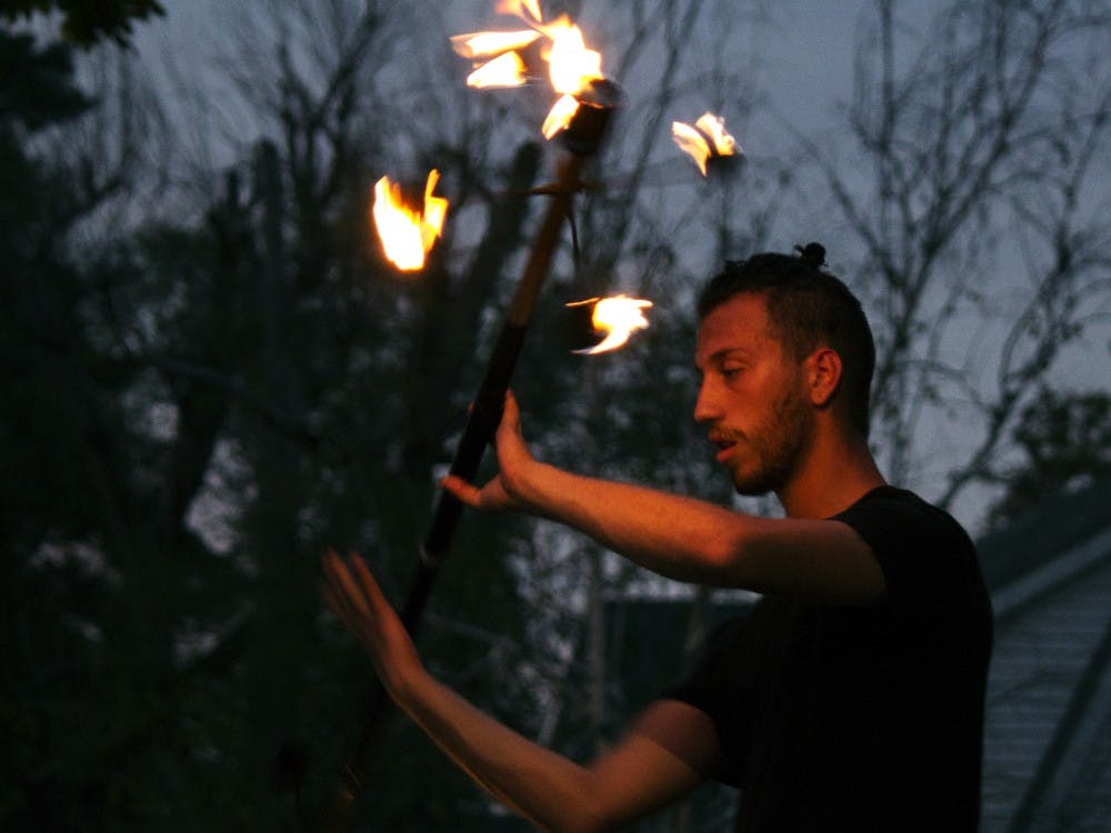 Cincinnati Circus Company’s fire performer, Adam Leite, twirls a lit pole on Monday, Sept. 28 at 7:42 p.m. at the Homecoming Village festival. 