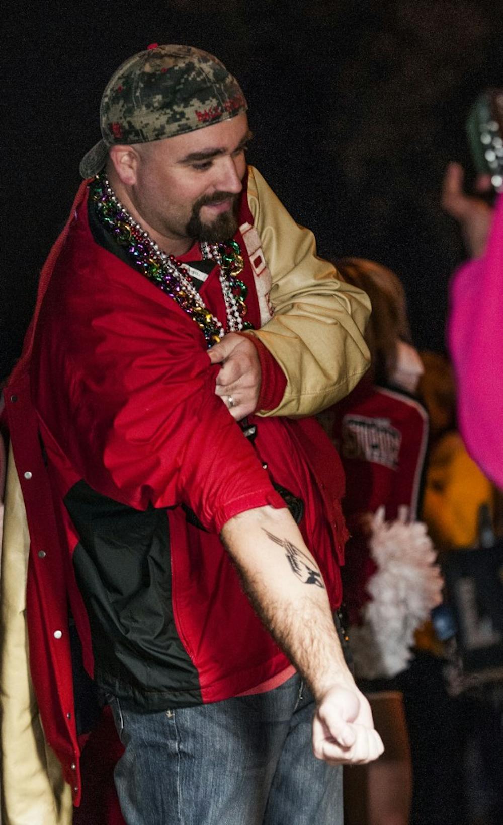 Bob Phelps shows off his tattoo to parade attendees during the pep rally on Jan. 4. Phelps recently fulfilled his college desire to get the tattoo. DN PHOTO JONATHAN MIKSANEK