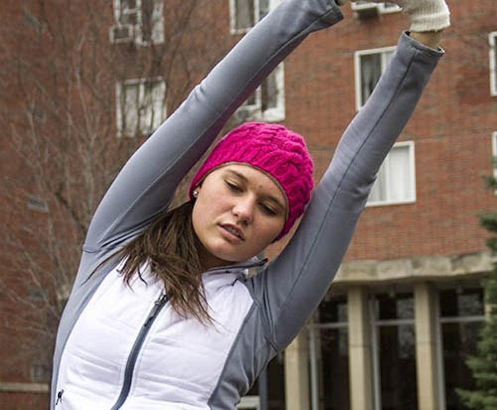 Freshman health science major Melissa Kahler stretches before her run Monday afternoon in the LaFollette Complex courtyard. DN PHOTO ILLUSTRATION EMMA FLYNN