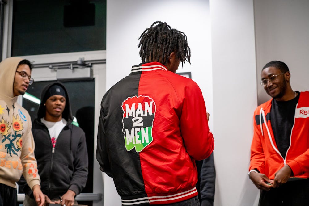 Fourth-year psychology Elijah Nemwan introduces the activity challenge to a group Feb. 17 at Multicultural Center. The challenge for Man2Men attendees addresses the methods of approaching romantic scenarios. Kate Tilbury, DN