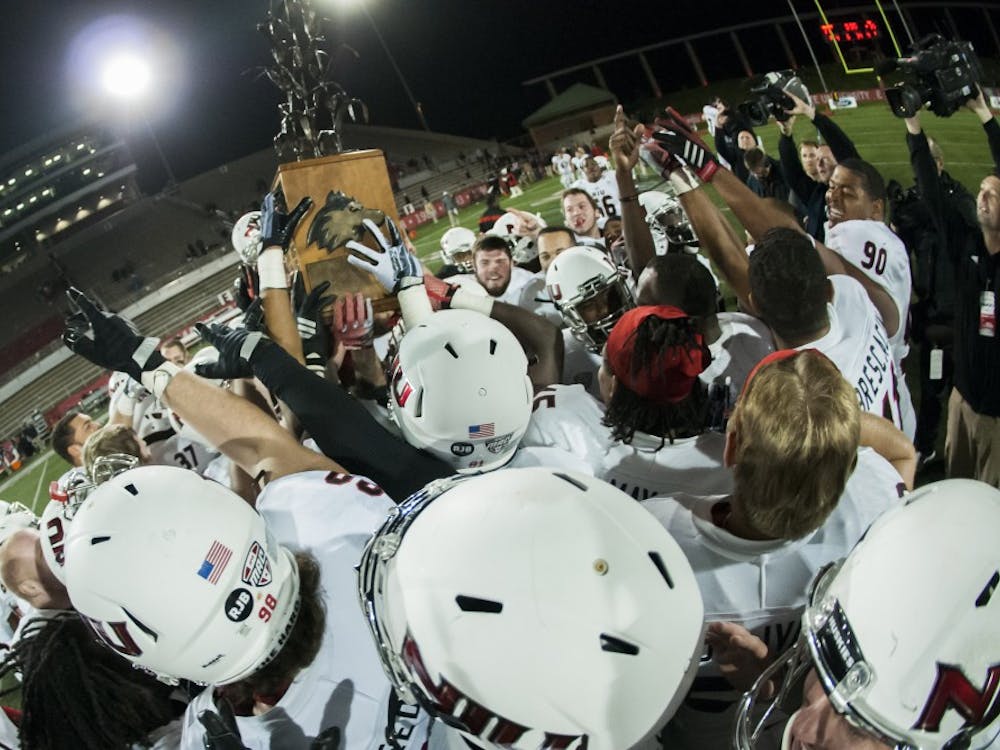 The Huskies hold the trophy at the end of the game against Northern Illinois on Nov. 5 at Scheumann Stadium. DN PHOTO JONATHAN MIKSANEK