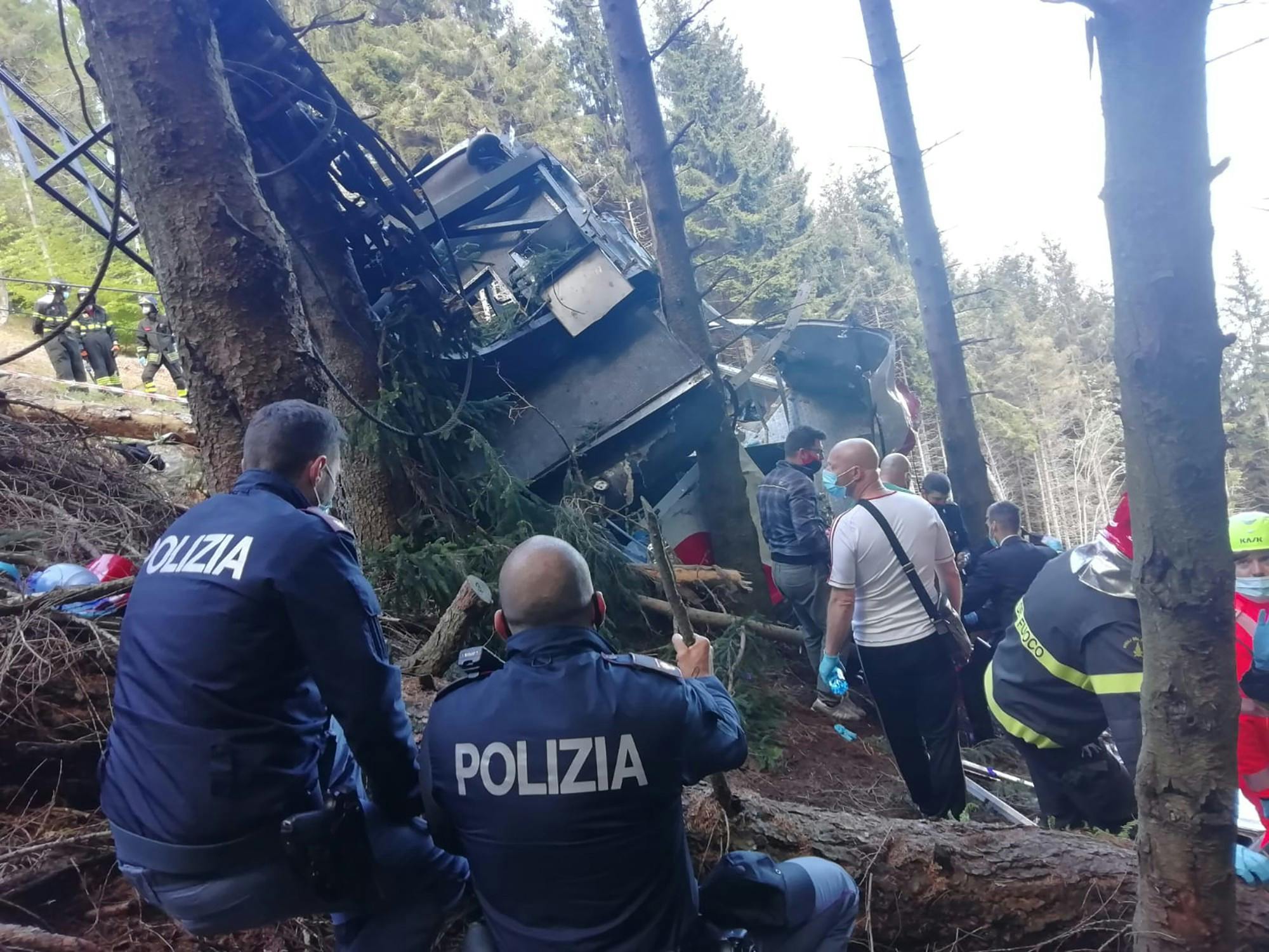 In this handout photo provided by the Italian state police, emergency workers surround the wreckage of a cable car that fell from the Stresa-Alpine-Mottarone line on May 23, 2021 in Stresa, Italy. After initial confusion over the number of passengers, Italian news outlets reported that 15 people had been riding in the cable car before it fell, and officials said two children were taken from the accident site to a hospital in Turin. (Handout photo by the Italian State Police via Getty Images/TNS)