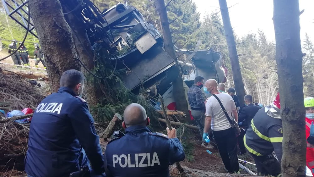 In this handout photo provided by the Italian state police, emergency workers surround the wreckage of a cable car that fell from the Stresa-Alpine-Mottarone line on May 23, 2021 in Stresa, Italy. After initial confusion over the number of passengers, Italian news outlets reported that 15 people had been riding in the cable car before it fell, and officials said two children were taken from the accident site to a hospital in Turin. (Handout photo by the Italian State Police via Getty Images/TNS)
