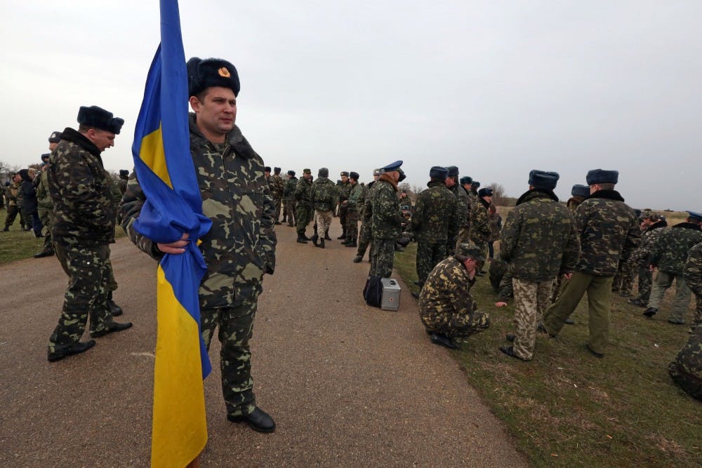 Lt. Col. Oleh Shapoval stands with a Ukraine national flag on the road leading to his unit
