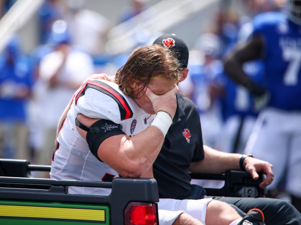 Graduate student linebacker Clayton Coll holds his head in his hand as he is carted off the field against Kentucky Sept. 2 at Kroger Field.  Despite leaving the game late in the second quarter, Coll had four tackles. Daniel Kehn, DN