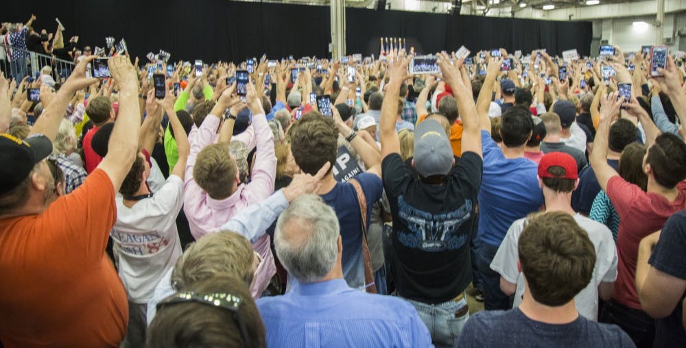 <p>Mixed crowds of supporters and protestors fill the Elements Financial Blue Ribbon Pavilion April 20 at a presidential rally for Donald Trump in Indianapolis. Cell phones rise as Trump enters the field house to begin his speech. <em>DN PHOTO TRENT SCROGGINS</em></p>