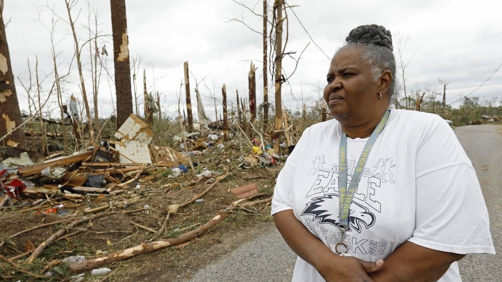 Sarah Cook looks at the remnants of houses and mobile homes April 13, 2020, in this Bassfield, Miss., neighborhood. Harper Town was one of many neighborhoods in Mississippi swept by a series of tornadoes, Sunday afternoon and evening. (AP Photo/Rogelio V. Solis)