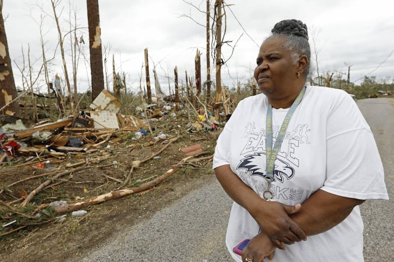 Sarah Cook looks at the remnants of houses and mobile homes April 13, 2020, in this Bassfield, Miss., neighborhood. Harper Town was one of many neighborhoods in Mississippi swept by a series of tornadoes, Sunday afternoon and evening. (AP Photo/Rogelio V. Solis)