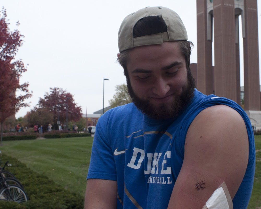 	Andrew Pizzano shows his wound Oct. 29. Pizzano said a robber stabbed him Oct. 26, but an email from the university says his account is false.