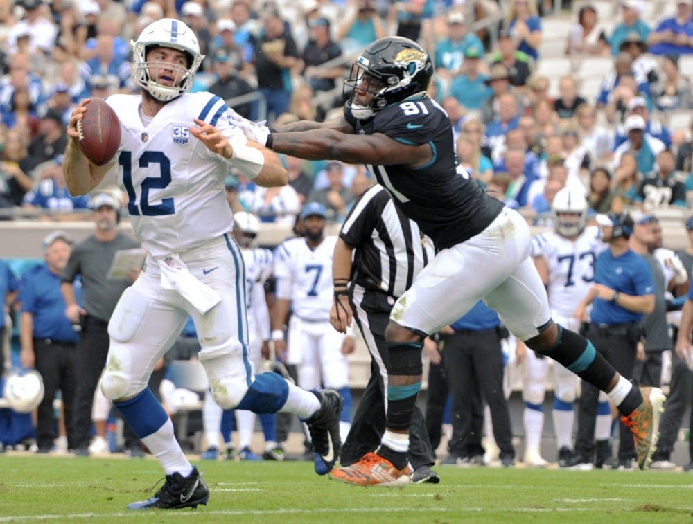 <p>Indianapolis Colts quarterback Andrew Luck (12) tries to elude Jacksonville Jaguars defensive end Yannick Ngakoue (91) on a scramble during early second quarter action. The Jacksonville Jaguars hosted the Indianapolis Colts at TIAA Bank Field in Jacksonville, Florida Sunday, December 2, 2018. The Jaguars went into the half with a 3 to 0 lead. <strong>Bob Self/ TNS</strong></p>
