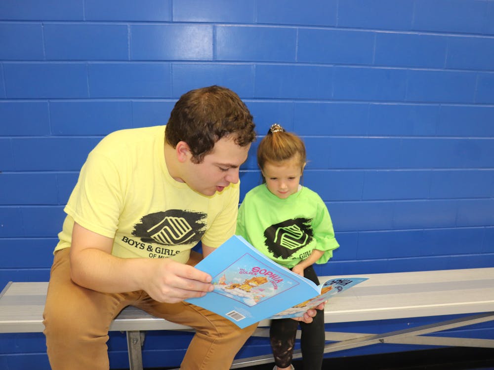 Domenic Bordenaro reads to a child at the Boys and Girls Clubs of Muncie, where he has served as the director of programs since August 2022. 