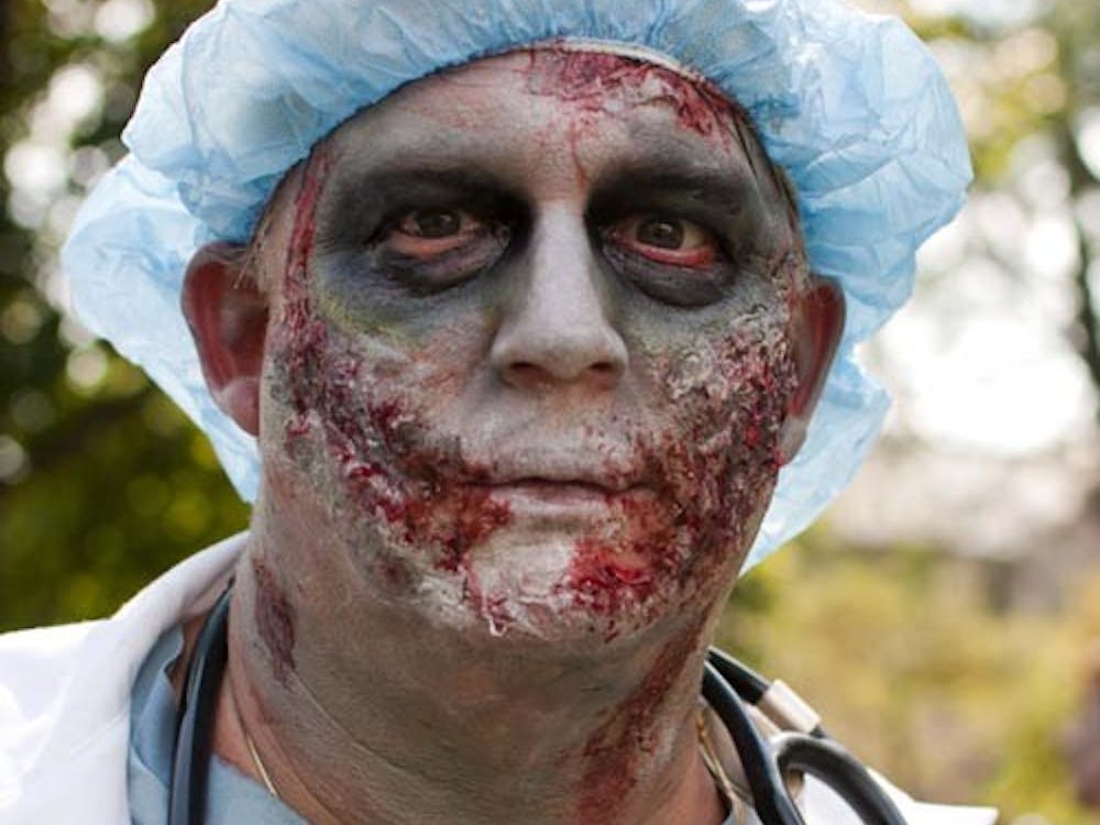 John Lee stares down the camera while in makeup for the Zombie Walk. Ball State’s campus looked and sounded like a horror movie Aug. 25 as bloody creatures rambled through the streets at the Muncie Zombie Walk. The charity walk collected donations for Muncie Animal Rescue Fund and Second Harvest Food Bank. More than 350 people attended, bringing 865 pounds of food for Second Harvest and 204 pounds of pet supplies for ARF, said Robert Abner, an organizer of the event, on the Facebook event page. DN FILE PHOTO BOBBY ELLIS