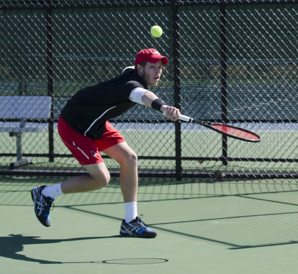 Freshman Patrick Downs reaches to hit the ball in his singles match against Toledo on March 30 at the Cardinal Creek Tennis Courts. DN PHOTO BREANNA DAUGHERTY