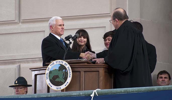 Gov. Mike Pence shakes Brent Dickson's hand after being sworn into office by the chief justice. DN PHOTO BOBBY ELLIS