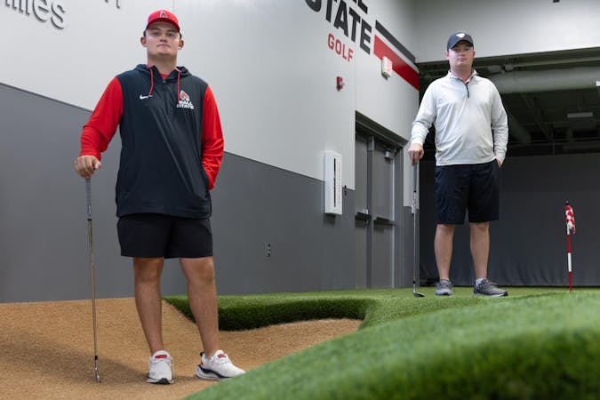 Brothers freshman golfer Gavin and redshirt senior Griffin Hare stand back to back for a photo Sept. 26 at Earl Yestingsmeier Golf Center. For Gavin and Griffin Hare, playing a sport together on the same team has been a dream since they were kids. Titus Slaughter, DN 
