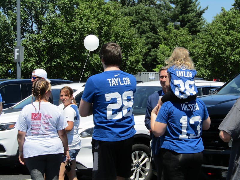 A seeming family of three waits in line during Indianapolis Colts quarterback Matt Ryan's autograph signing at Kia of Muncie and Toyota of Muncie's Tent Sale July 22, 2022. The man and young girl in the photo are wearing Colts halfback Jonathan Taylor's jersey while the woman wears former Colt and now free agent wide receiver T.Y. Hilton's jersey. (Kyle Smedley/DN)