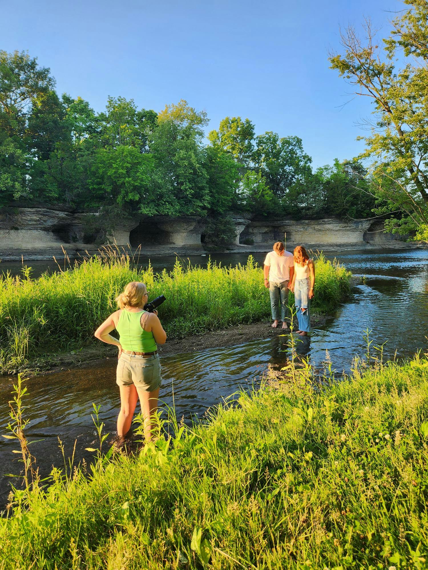 &nbsp;Layla Durocher stands in the Mississinewa River at Seven Pillars Nature Reserve. Durocher is instructing a couple, Mason Taylor and Anna Borden, on posing techniques for their couples session taken on July 10th, 2023.