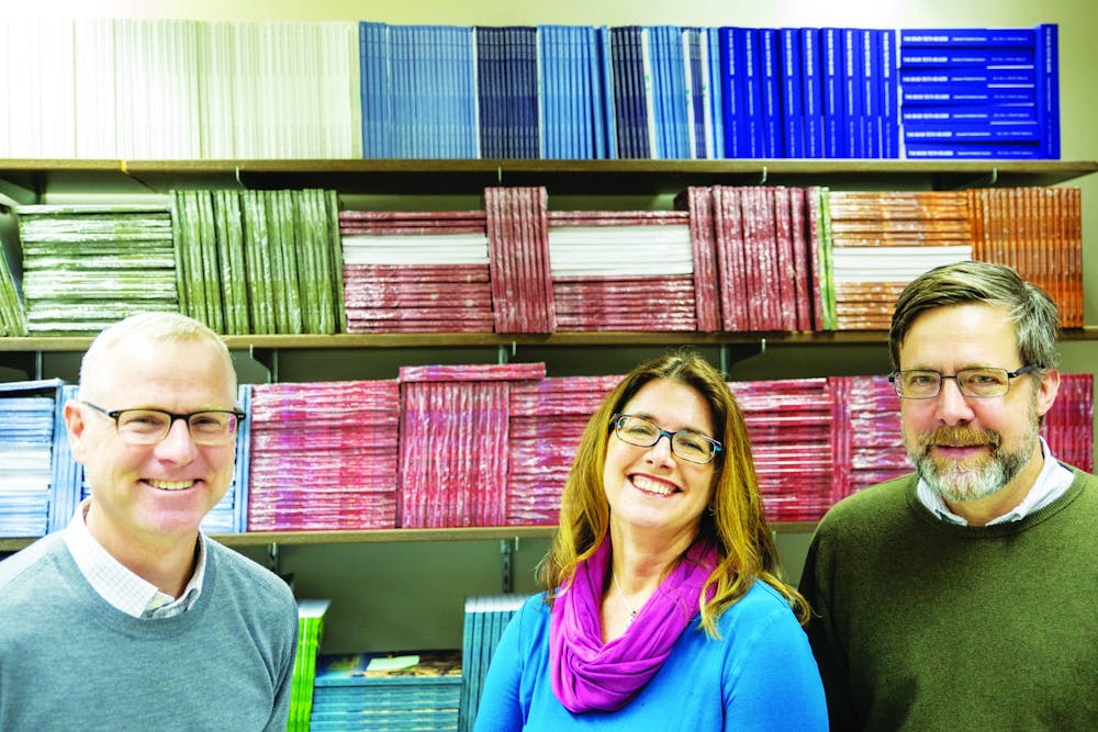 <p>Todd McKinney, Jill Christman, and Mark Neely (left to right) stand in front of the past issues of “River Teeth,” Jan. 13, 2020. “River Teeth” is a literary journal that publishes memoirs, essays, and other nonfiction narratives. Joshua Smith, DN</p>
