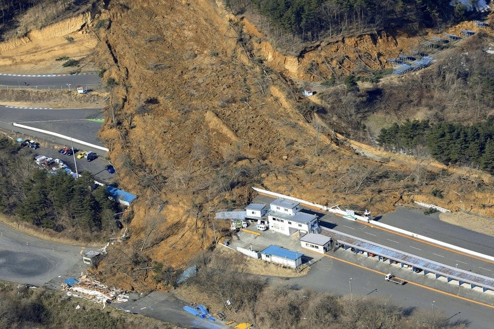 A landslide caused by a strong earthquake covers a circuit course in Nihonmatsu city, Fukushima prefecture, northeastern Japan, Sunday, Feb. 14, 2021. The strong earthquake shook the quake-prone areas of Fukushima and Miyagi prefectures late Saturday, setting off landslides and causing power blackouts for thousands of people. (Hironori Asakawa/Kyodo News via AP)