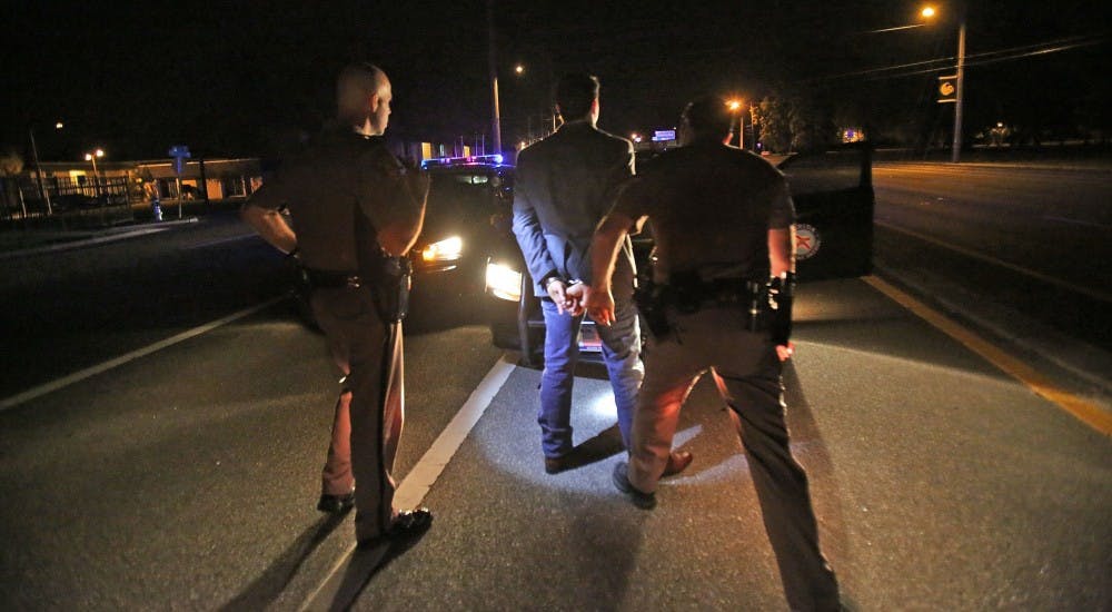 Mark Castleberry and Trooper J.C. Ramirez arrest Bryce Valin, 19, for DUI on April 3 across from the University of Central Florida. A new campaign in Delaware County called the Drive Sober or Get Pulled Over campaign, could see many more arrests like these on and around campus. MCT PHOTO