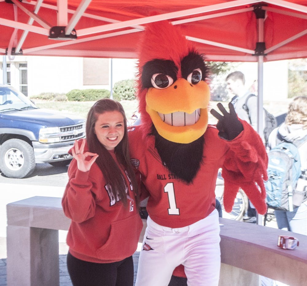 Sophomore medical technology student Shelby Sneed celebrates with Charlie Cardinal at the scramble light after winning the Chirp! Chirp! Spirit Scholarship contest. DN PHOTO COLIN GRYLLS