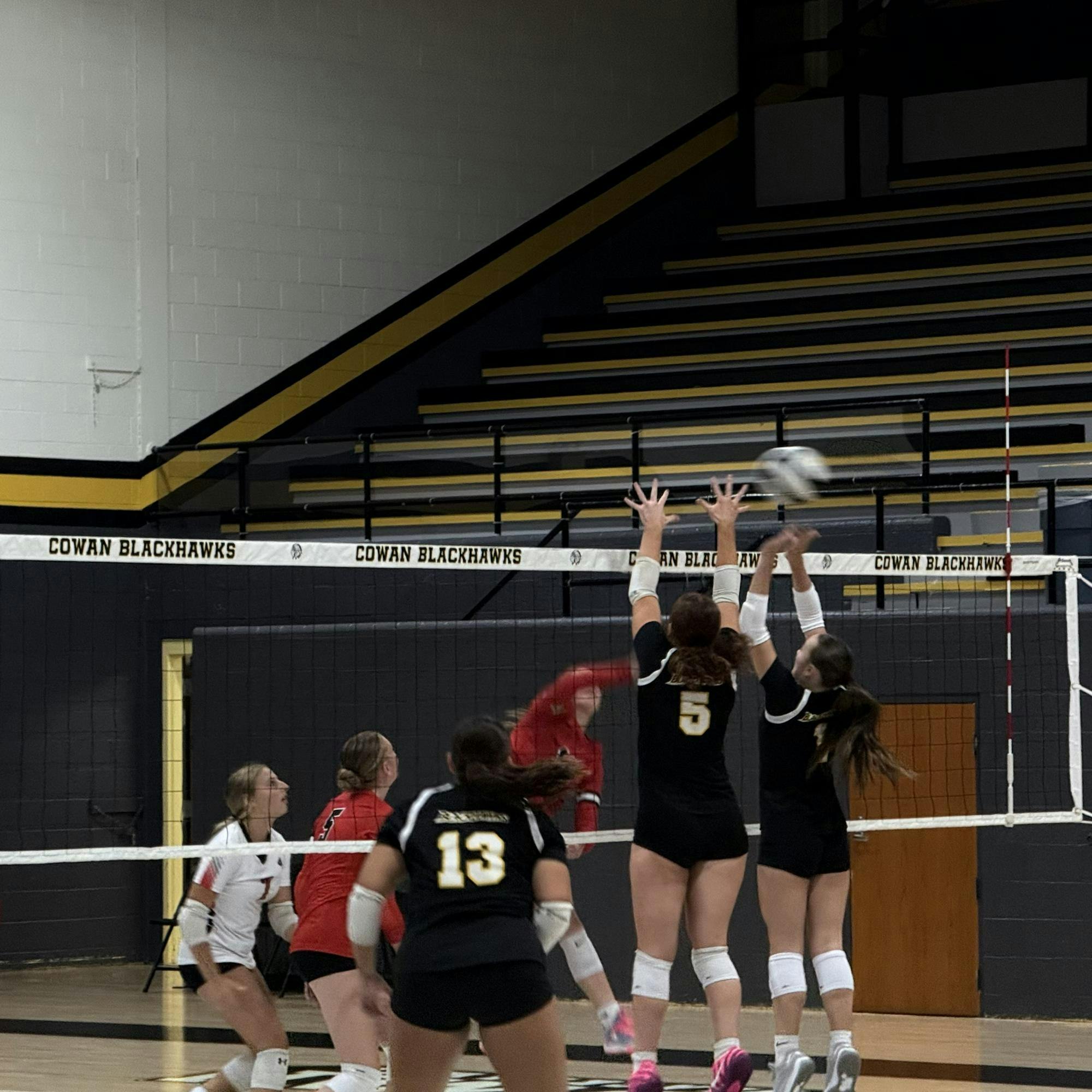 Cowan junior outside hitter Savannah Hall (#5) and junior opposite Brylynn Coon (pictured right) go up for a block attempt Sept. 18 at Cowan high school. Hall leads the team with kills with 56. Photo by Kyle Stout

