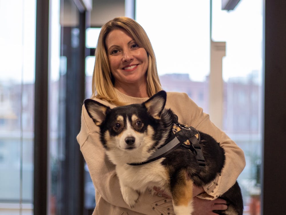 Kimberly Jeselski stands with her "office dog" Babette Jan. 17, 2020, in Indianapolis Ind. Babette stays in Jeselski's office but will wander around the office space and sometimes into other people's offices. Jacob Musselman, DN