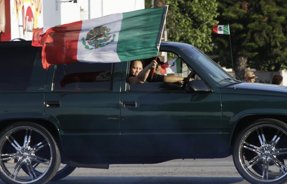 Soccer fans wave the Mexican flag in Huntington Park, Calif., as they celebrate the team's 3-1 World Cup win against Croatia, Monday, June 23, 2014.  (Lawrence K. Ho/Los Angeles Times/MCT)