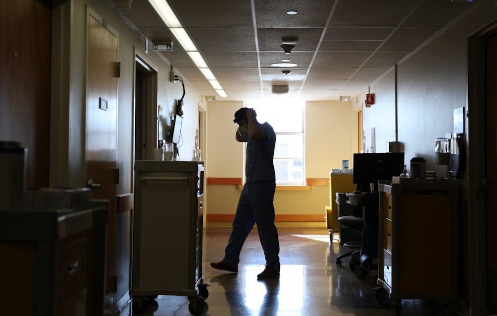 Warren Gavin dresses in personal protective equipment before entering a patient’s room Feb. 8 at Indiana University Health Methodist Hospital in Indianapolis. Gavin said about 70 percent of the patients he treats are unvaccinated.  Rylan Capper, DN 