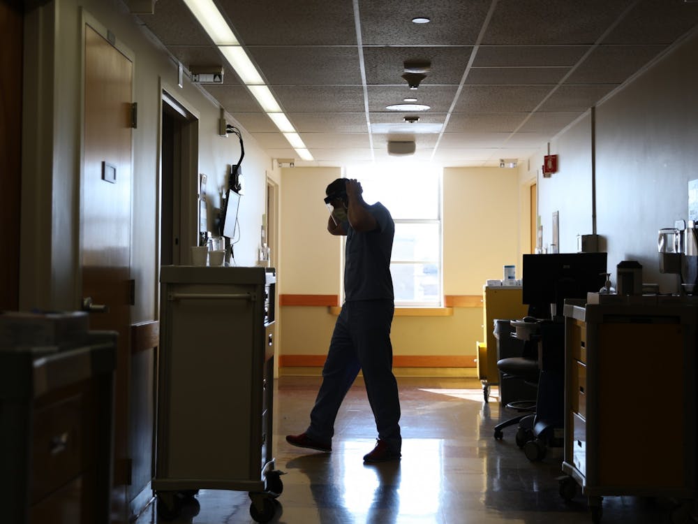 Warren Gavin dresses in personal protective equipment before entering a patient’s room Feb. 8 at Indiana University Health Methodist Hospital in Indianapolis. Gavin said about 70 percent of the patients he treats are unvaccinated. Rylan Capper, DN
