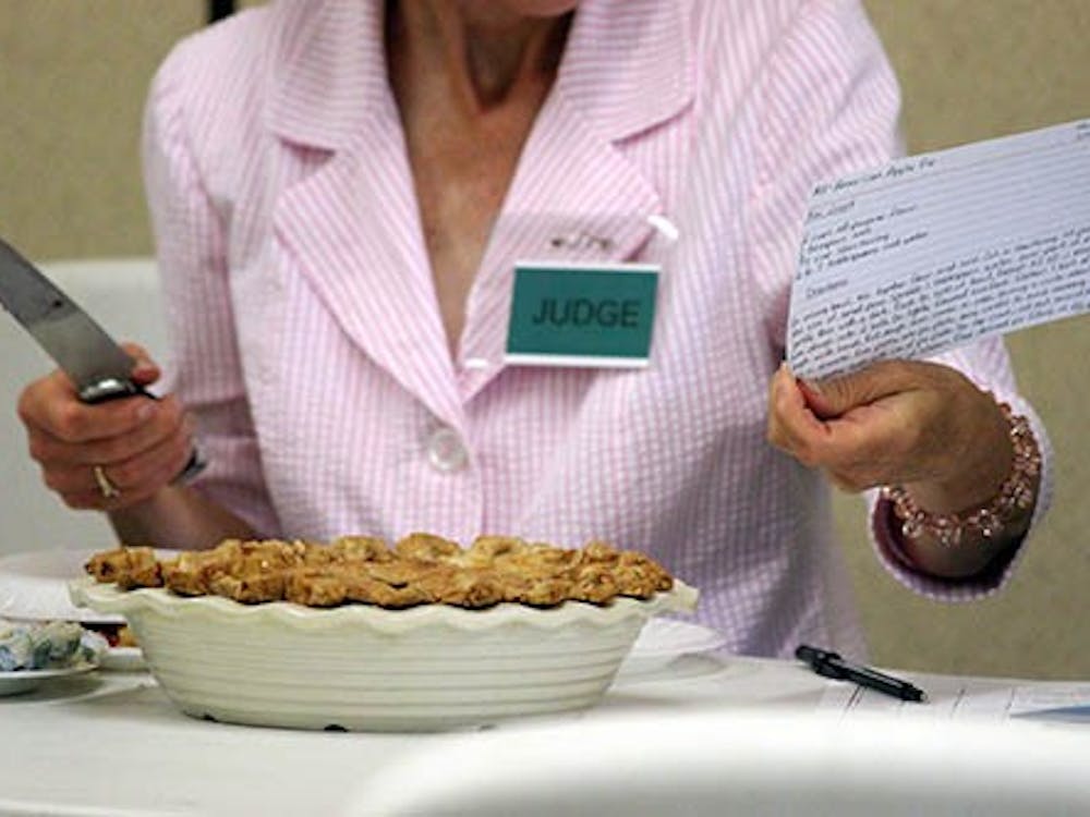 A 4-H judge prepares to cut into an 'American Apple Pie.'  The 4-H fair will be in town until the 18th of this month.  DN PHOTO KRYSTAL BYERS