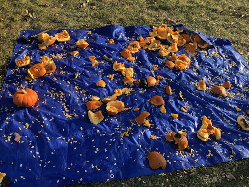 Surrounding University Green,  smashed pumpkins lie on top of a blue tarp Oct. 6, 2022. The smashed pumpkins were used as part of an event titled “Smash Domestic Violence,” for domestic violence awareness month. Zach Gonzalez, DN