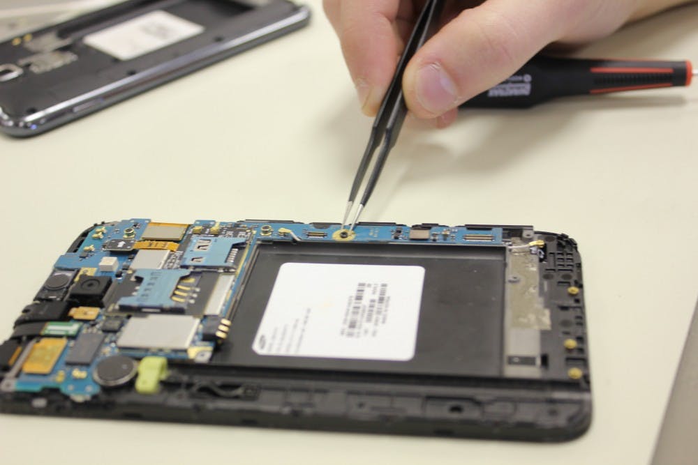 Justin Dunmyer works on a phone at MDtekk. Dunmyer and his business partner, Zachary Marvel, customize and repair cellphones. DN FILE PHOTO HANNAH SICHTING